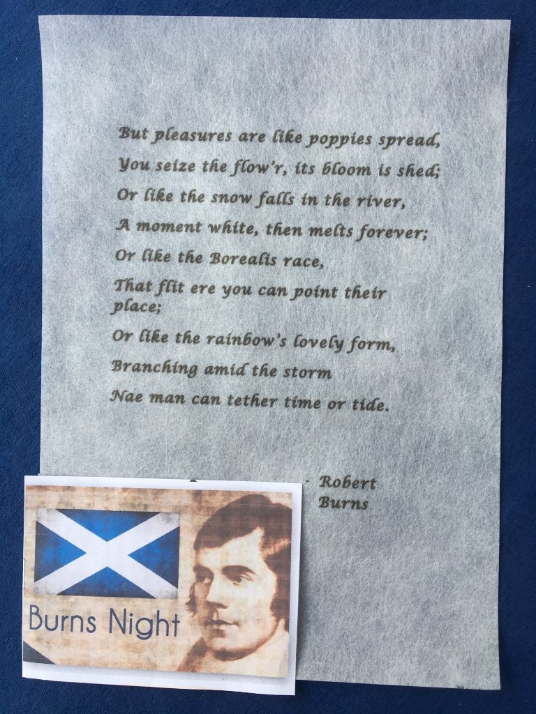 A poem written by Robert Burns, printed in black ink (using a font resembling handwriting), on an A4 piece of Zeelon Heavy, Inset is a picture of the face of Robert Burns facing left, beside an image of the Scottish flag.